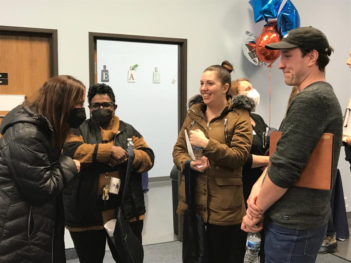 Four guests smiling and talking at the DNEM Fort Gratiot office open house.