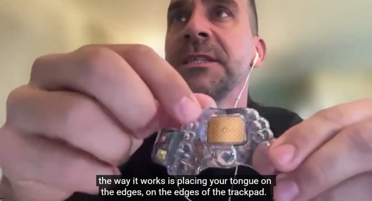 Screenshot from an Accessibility in Your Community Webinar that demonstrated Mouthpad^. The captions say, the way it works is placing your tongue on the edges, on the edges of the trackpad.