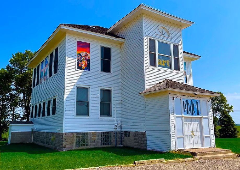 Two story white house with art in the windows 