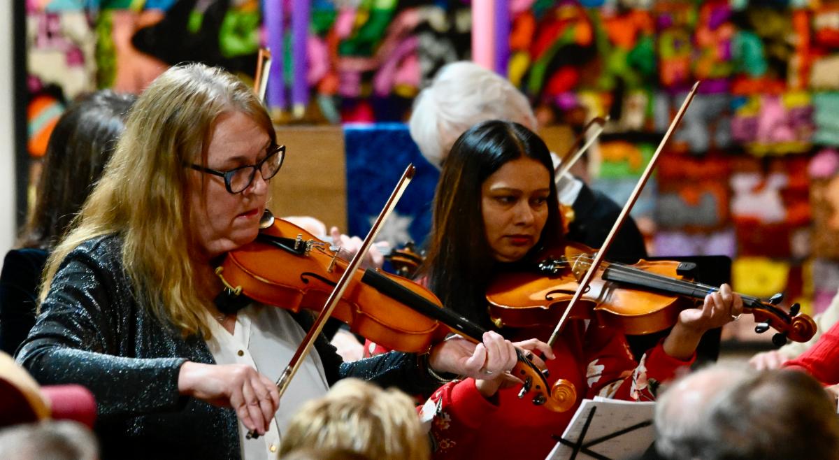Fiddlers playing in an indoor concert