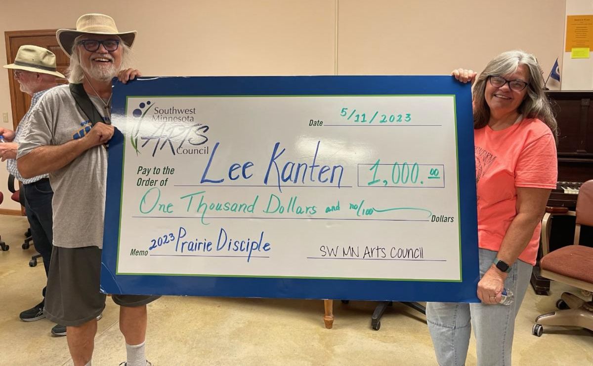 Lee and Jeanie stand with oversized award check for $1,000