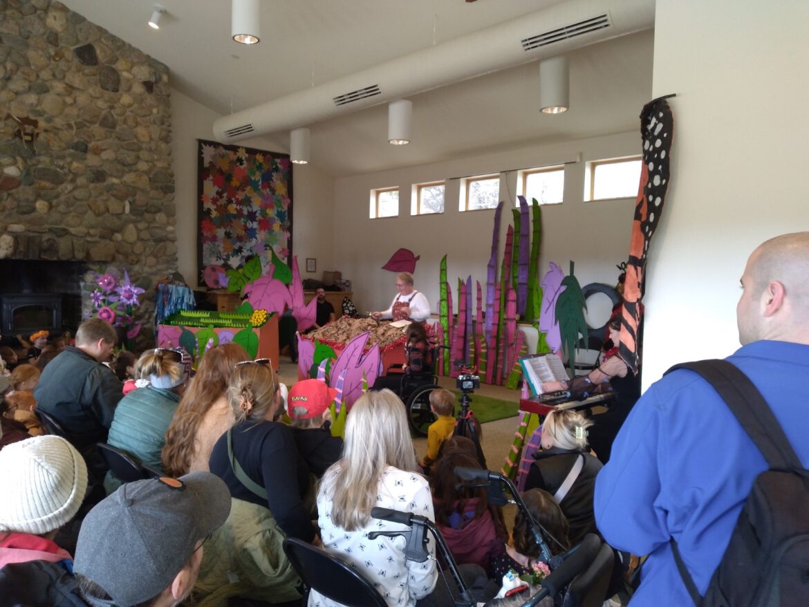 Community play taking place inside a build. Kids are dressed up as butterflies.