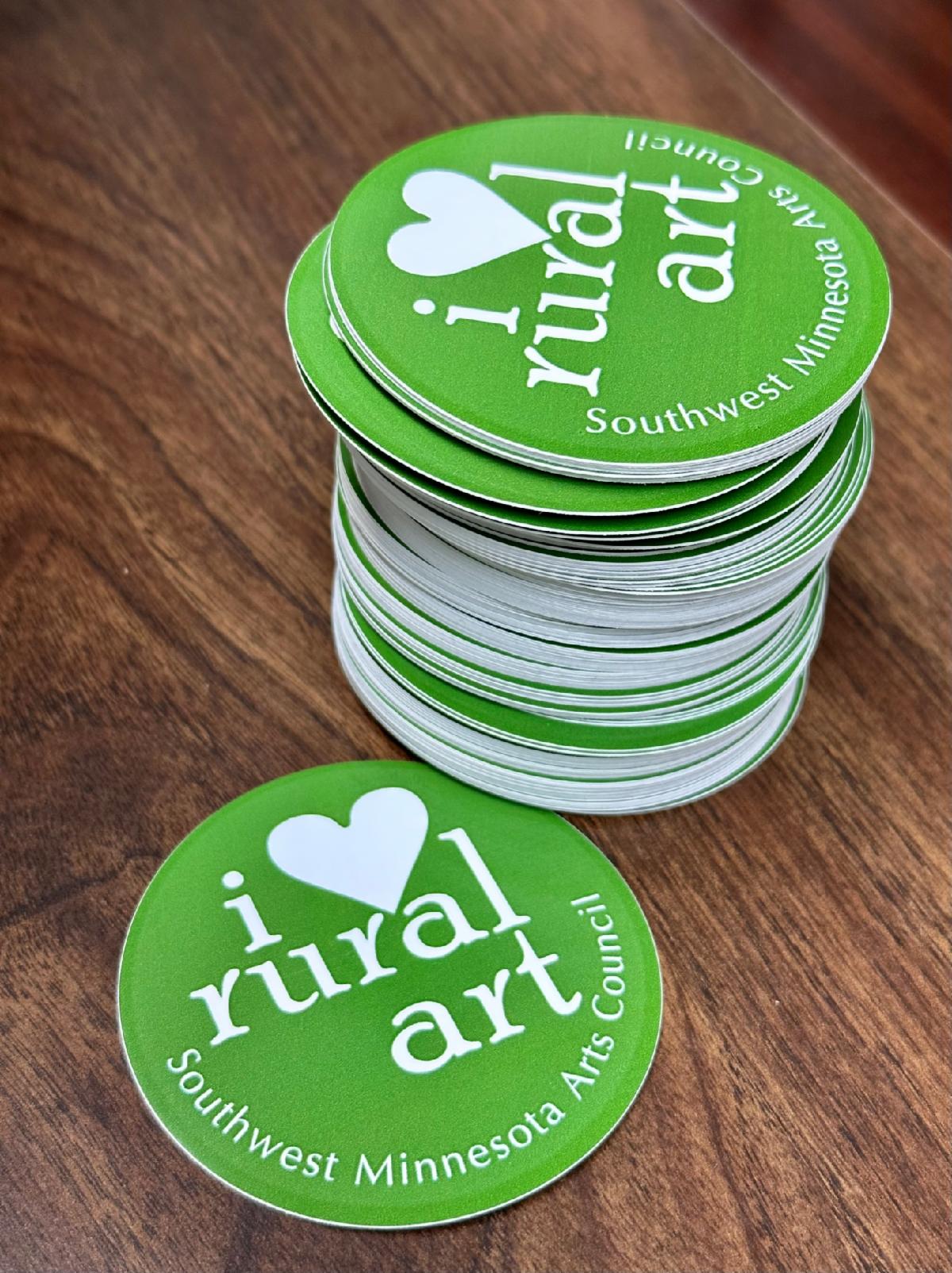 stack of "I love rural art" stickers in dark green