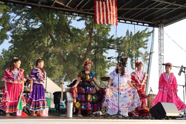 People in colorful dresses dancing on outdoor stage