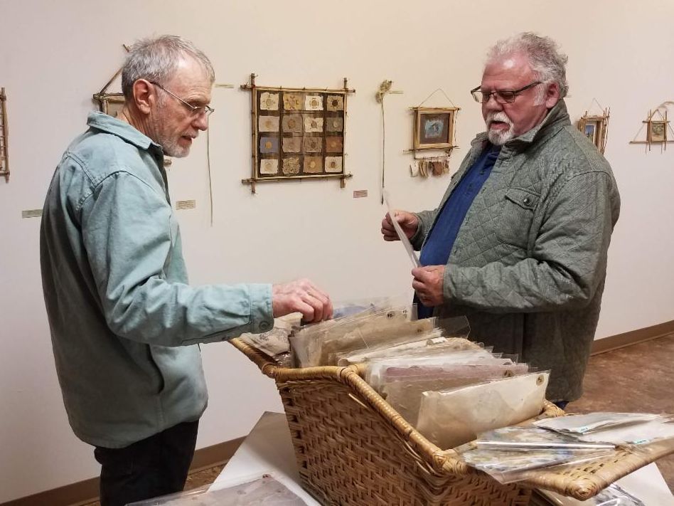Don discusses his paper that's for sale with a guest at the exhibit.