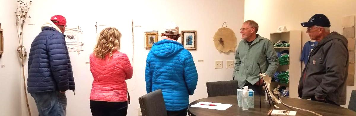 A group of guests looks at Don's work at his artist reception