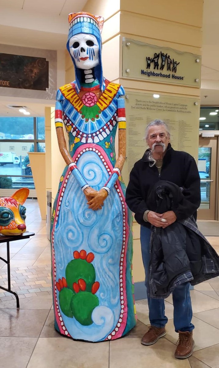 Artist Gustavo Boada next to Dia de Los Muertos Catrina sculpture