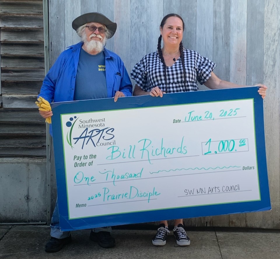 Bill Richards and Nicole DeBoer pose with large Prairie Disciple check