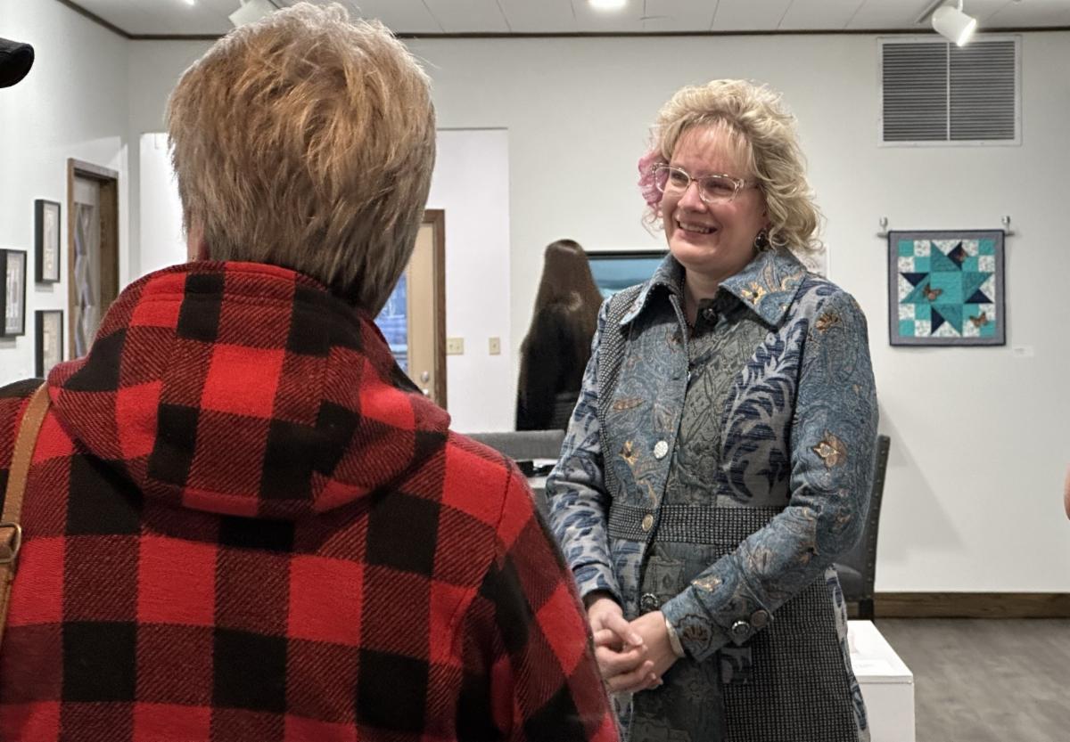 Laura Deleski talks with guests at artist reception.