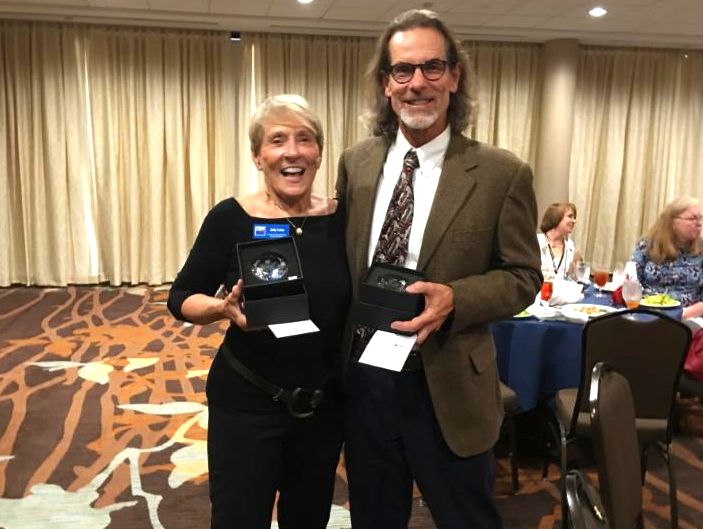 Judy Lotas and Craig Merrill with awards for leading League Action Teams