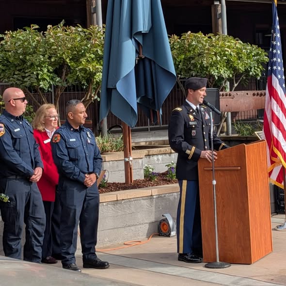 Community members and public safety personnel gathered at a podium during Yountville’s 9/11 remembrance ceremony. This image accompanies the 25th anniversary remembrance story.