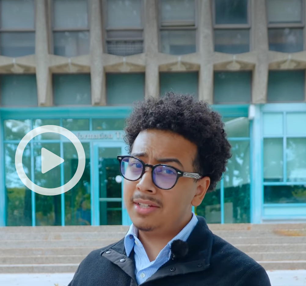 Still image of student infront of Carman Hall