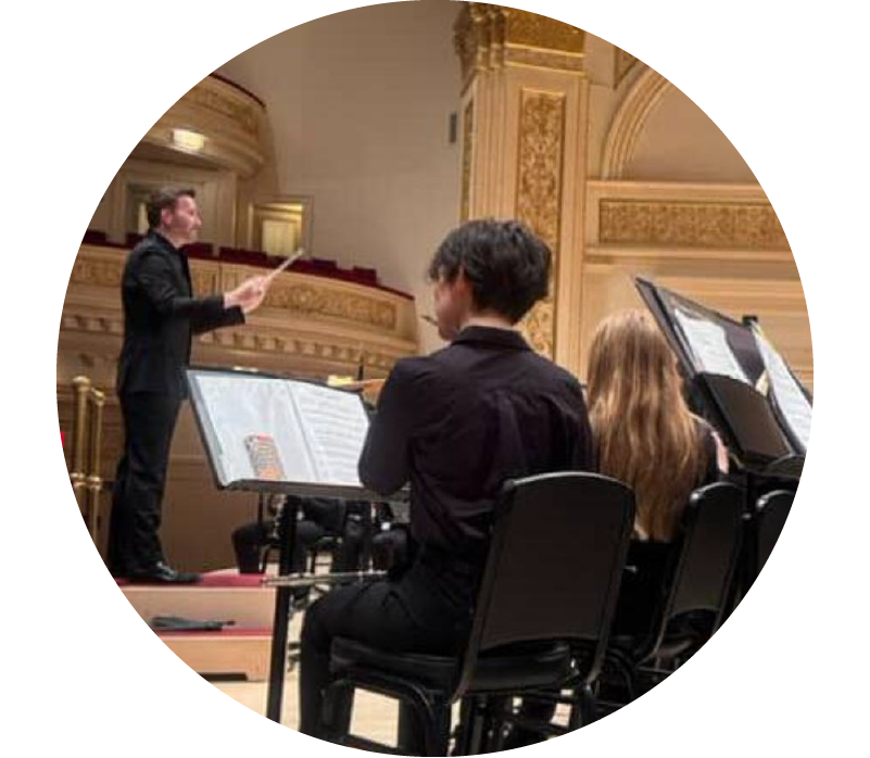 Circular thumbnail of conductor on stage and young musicians