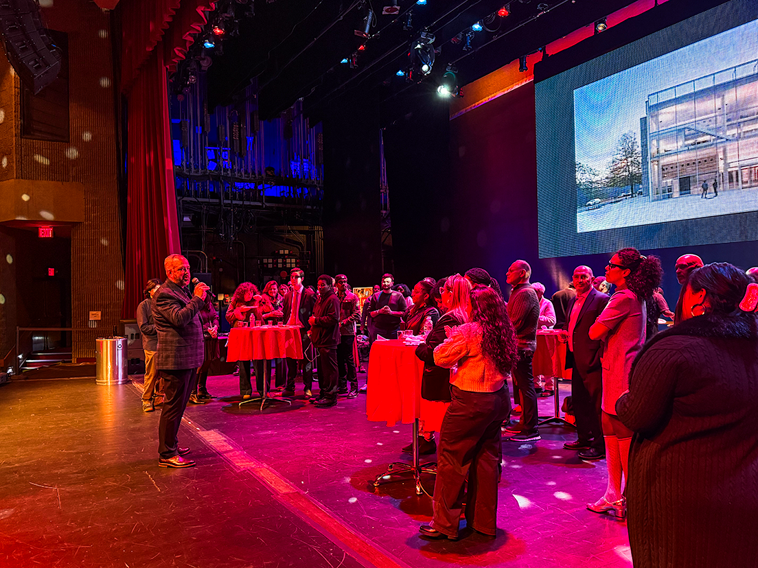 Stage glowing pink with large gathering of guests