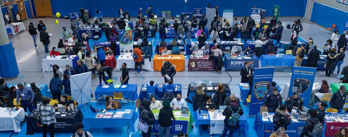 Room full of tables at prior fair with students engaged in the event