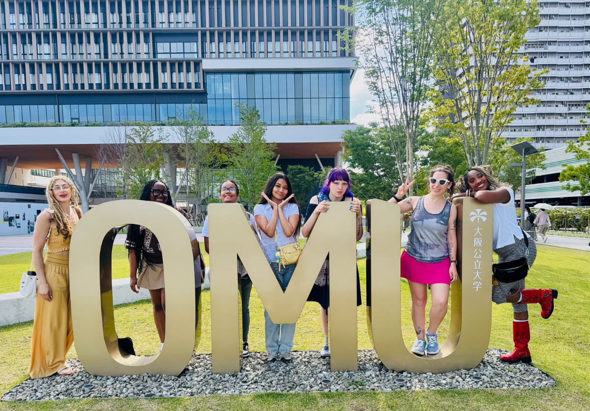Lehman Students in front of Giant OMU Campus sign