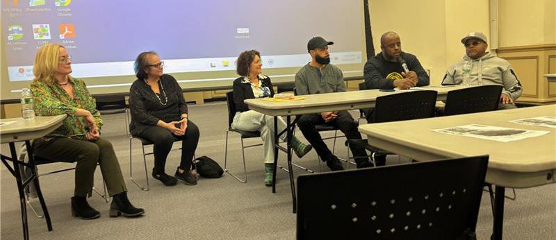 A panel sits at the front of a classroom
