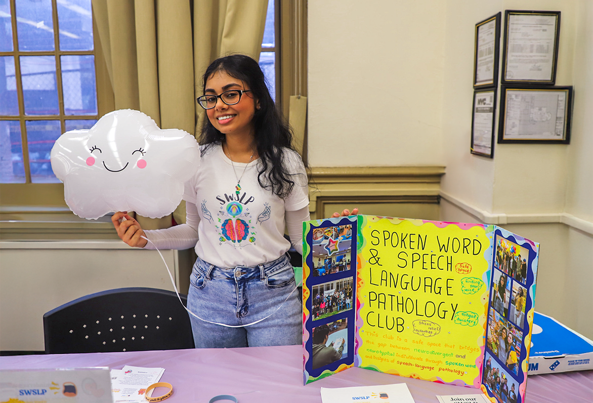 Speech Language Hearing Club Student Holds Happy Cloud Balloon