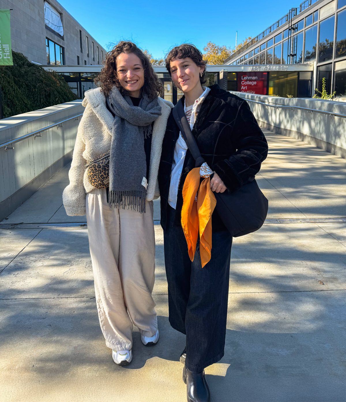 Two young women pose in front of Shuster Hall and Art Gallery Entrance