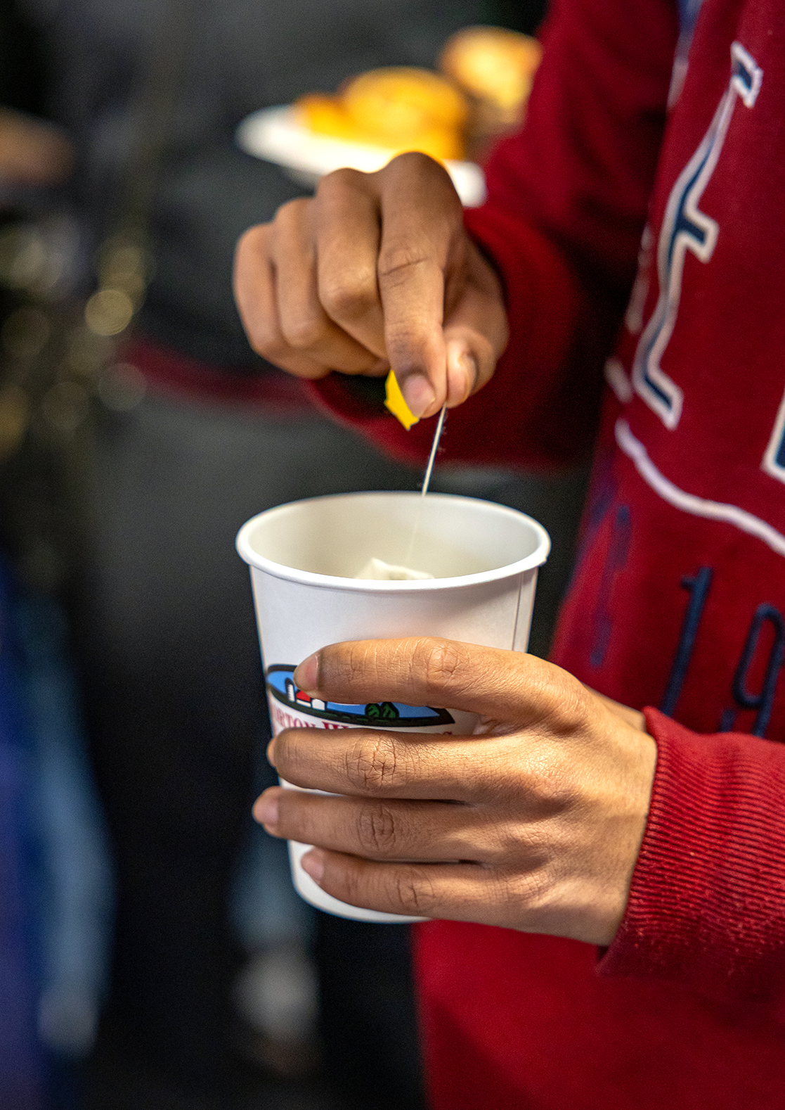 Closeup of hands holding a paper cup of tea