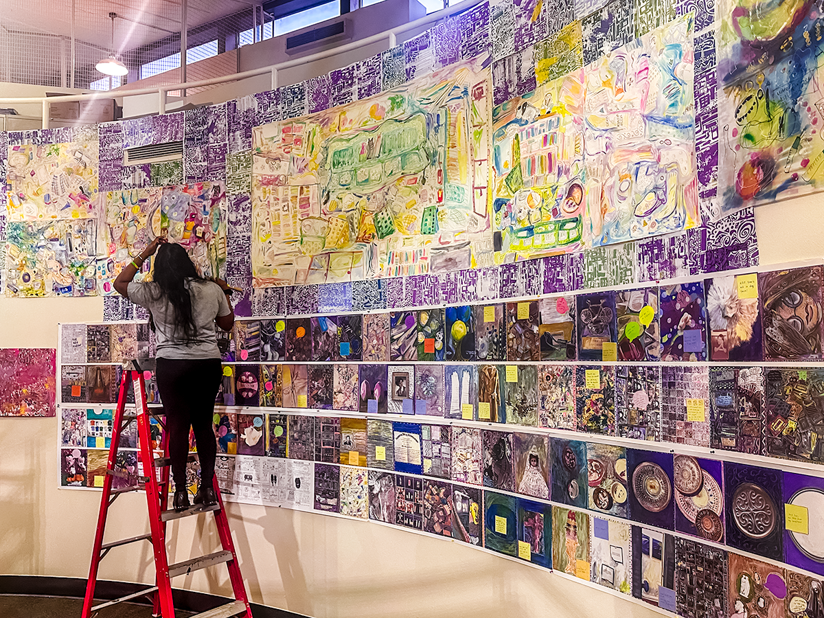 Student Adding Art to filled rotunda wall