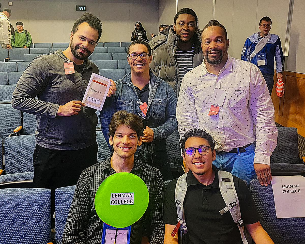 Group Shot in Auditorium with Lehman College paddle