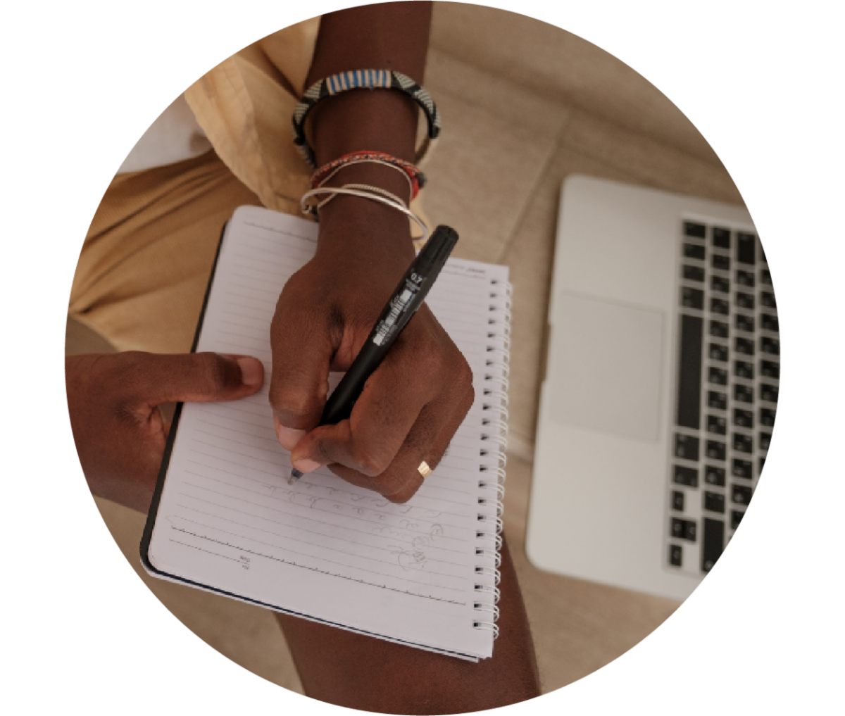Stock image of hand writing next to computer