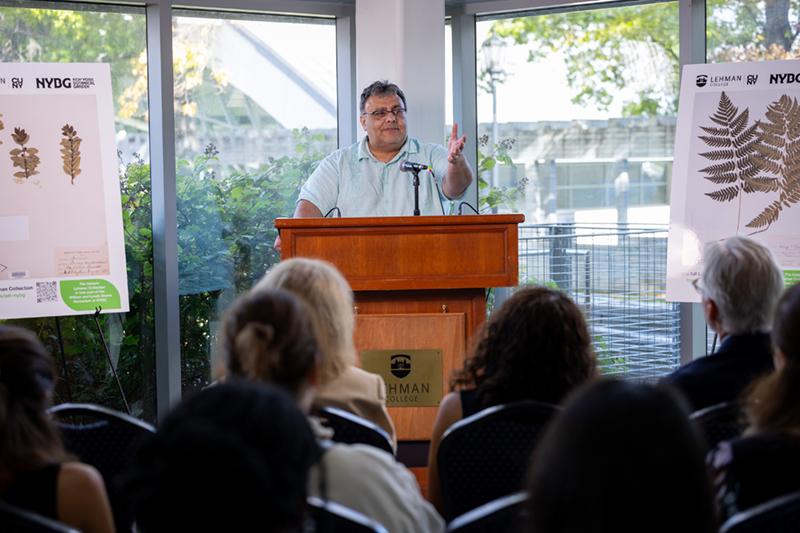 President Delgado speaking at the podium at the handing over of the herbarium handover celebration.