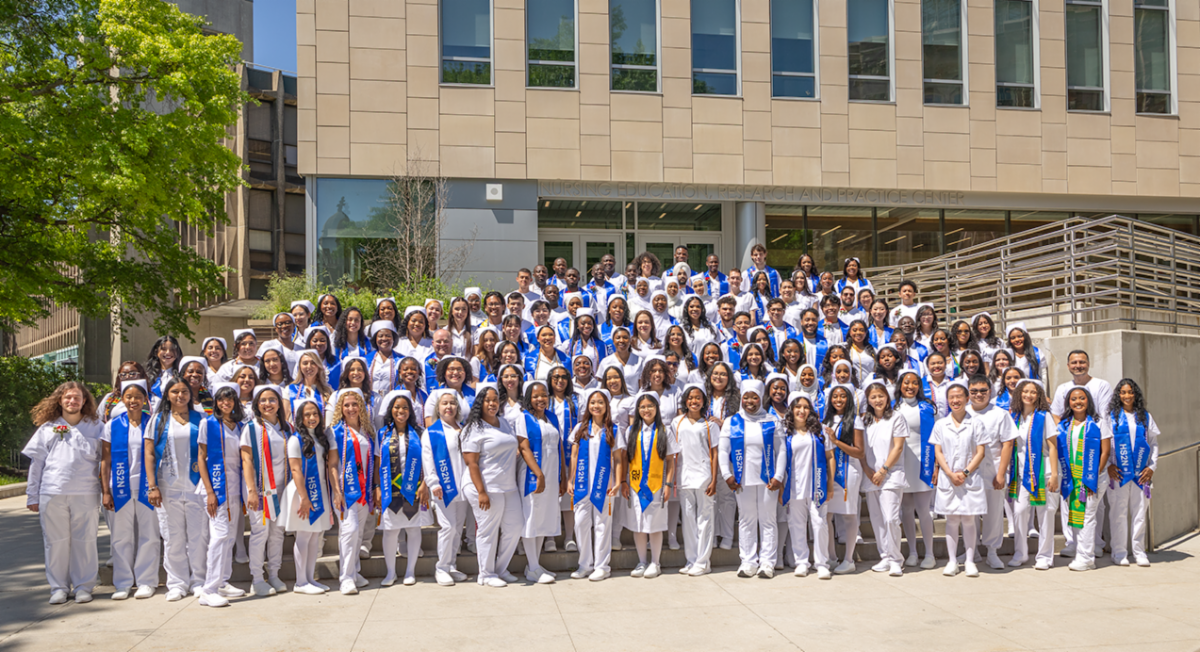 Nursing graduates in front of Lehman's Nursing building