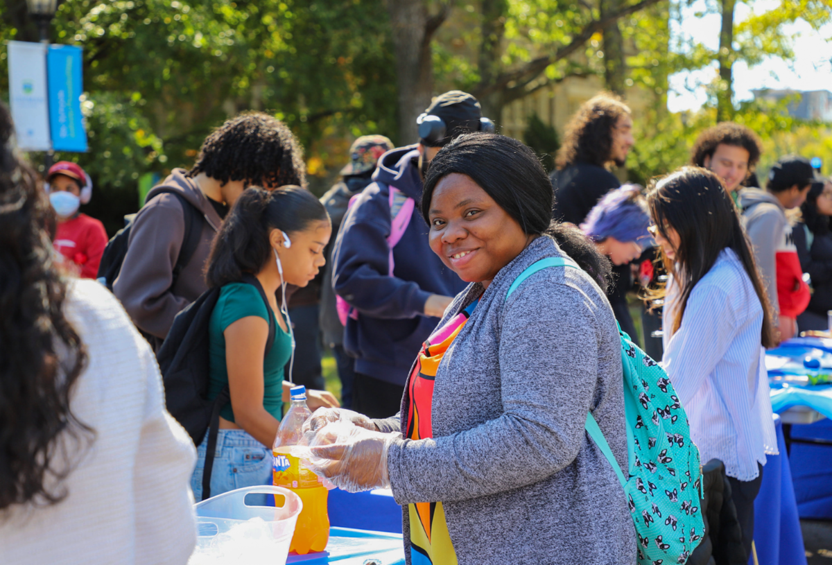 Female amongst crowd of students smiling during The Counseling Center World Mental Health Day event