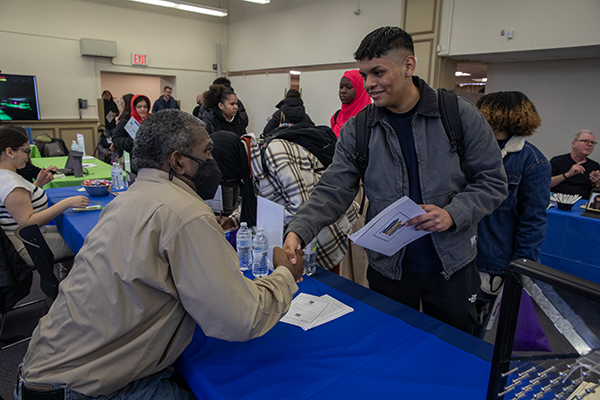 Table with Prof and students shaking hands