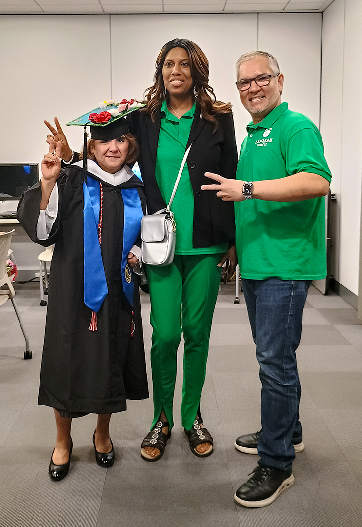Veronica gives a peace sign while posing with commencement volunteers