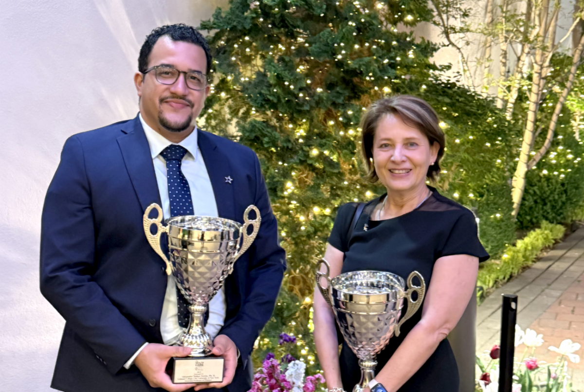 Professor Alexander Núñez-Torres and Dean Dene Hurley stand with trophies 