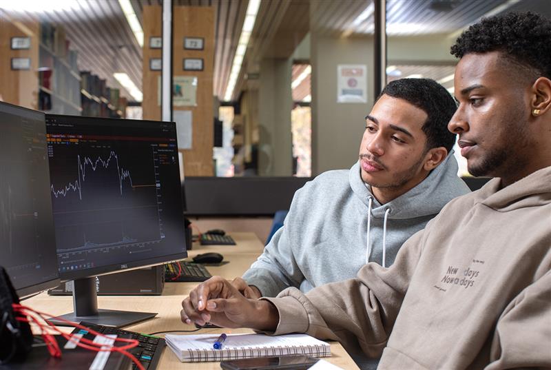 Photo of two young men at a computer