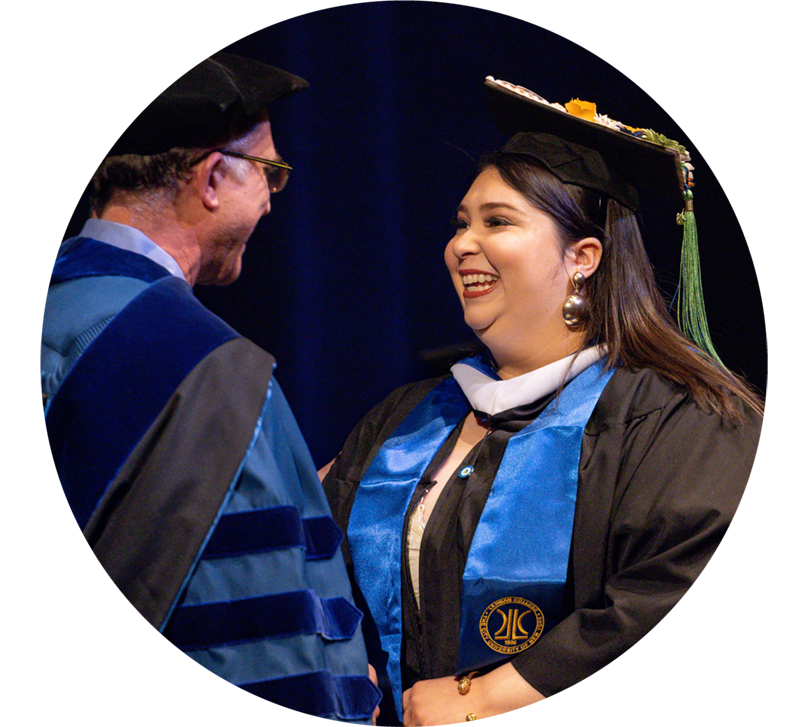 winter commencement speaker shakes hands with a dean at ceremony