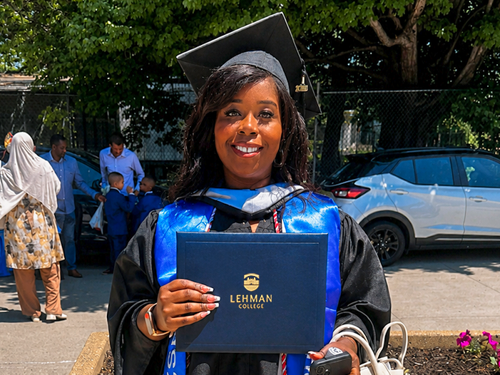 Nicole Scott posing with degree folder