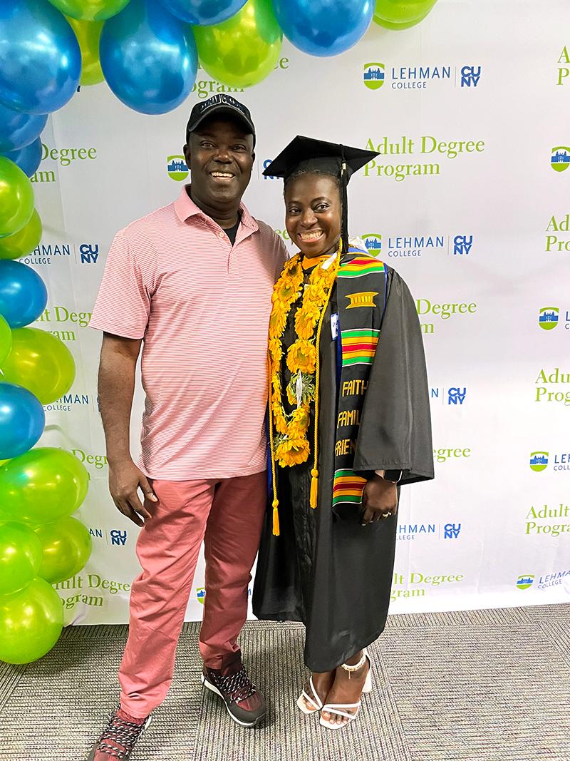 Graduates in front of step and repeat and balloons