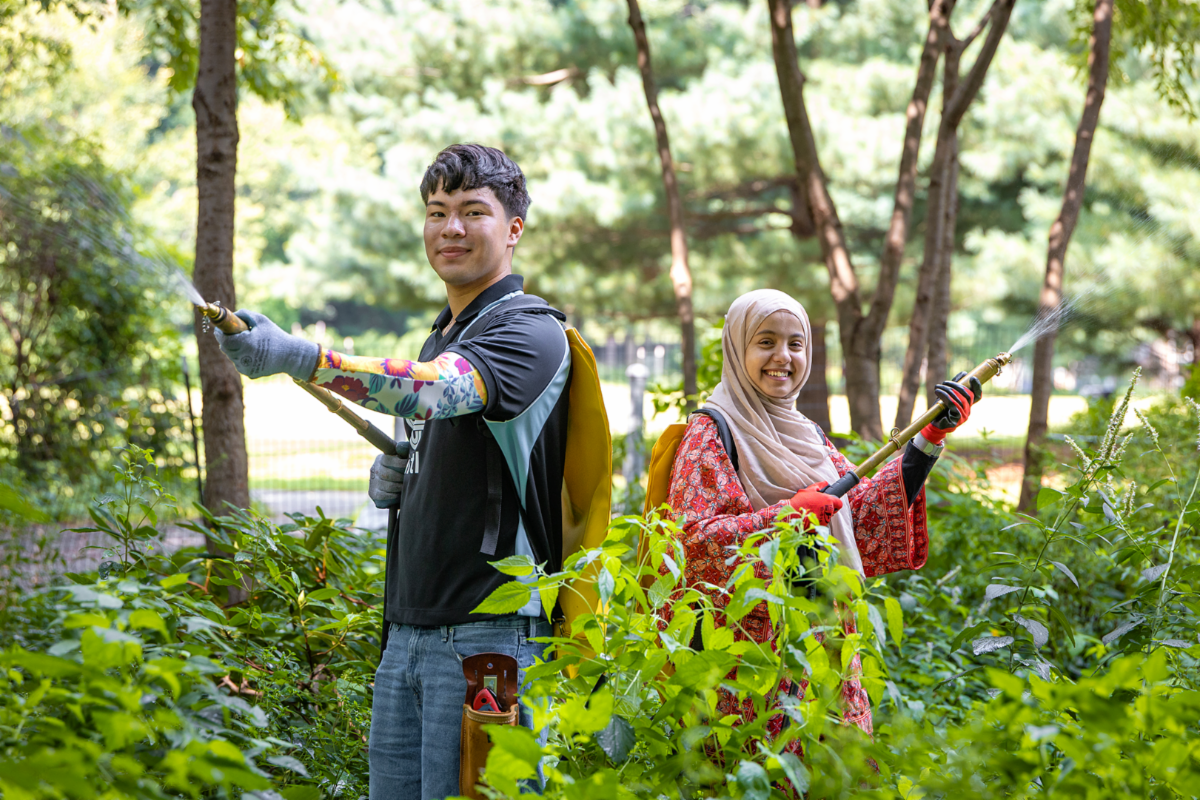 Two students in garden with equipment for revitalizing