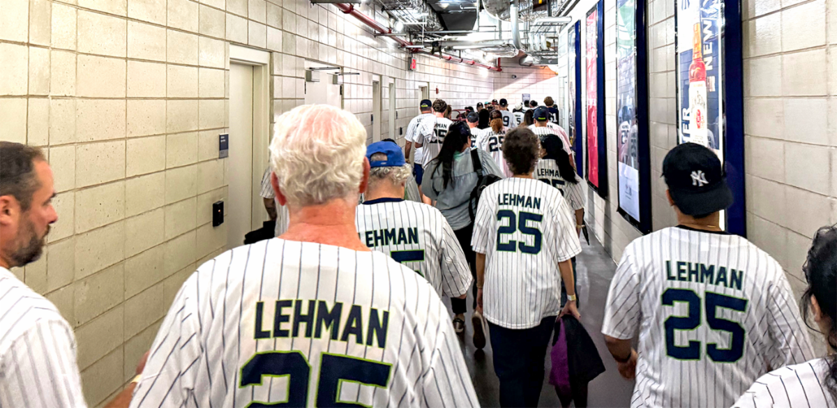 Photo of Lehman Alumni and Staff in Lehman Yankees shirt walking in group at the Yankees stadium