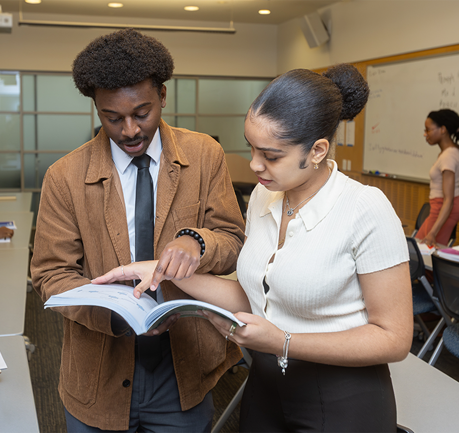 Two Students look at a book