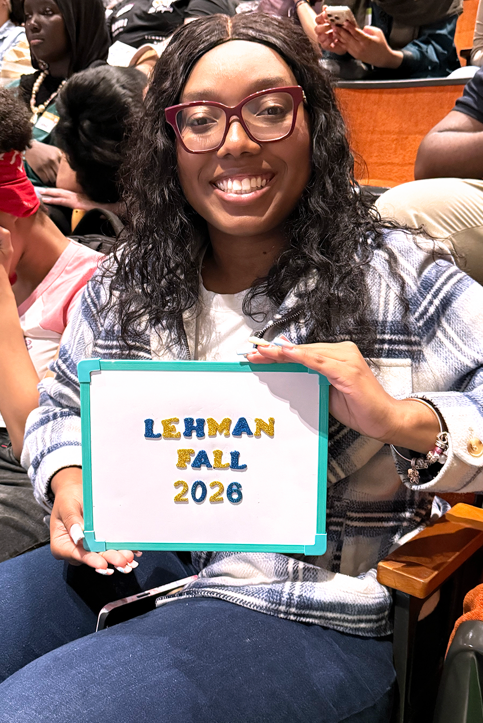 Student holds a Lehman Fall 2026 Sign