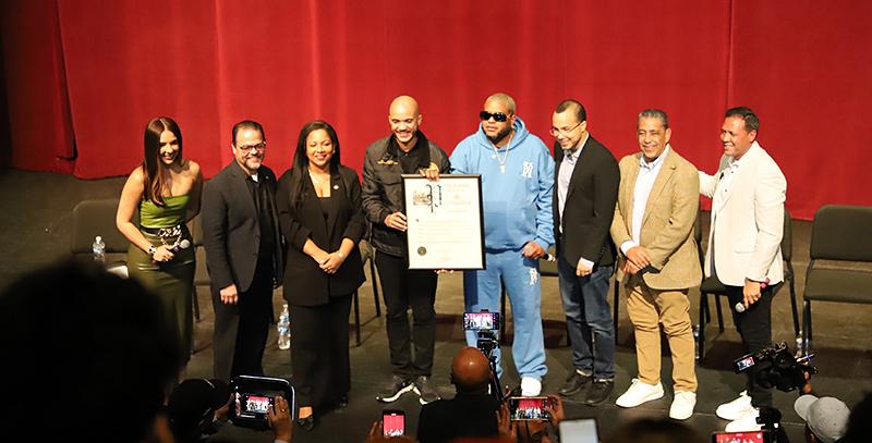 Stage Photo with red backdrop and proclamation in hand