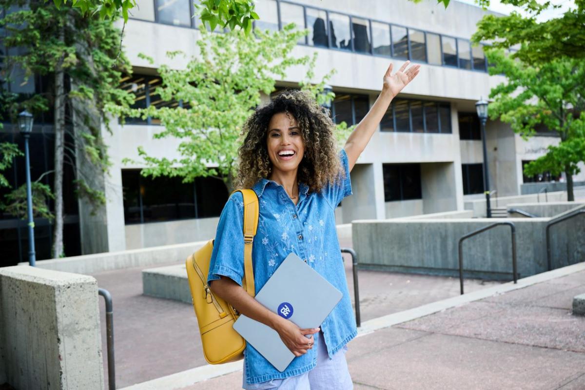 A student holds her hand high with excitement