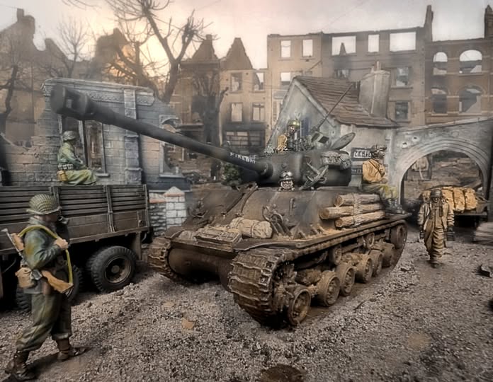 US tank with soldiers in ruined town
