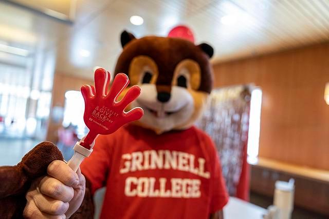 Scarlet the Squirrel mascot holds up a Scarlet and Give Back Day giveaway item in the JRC