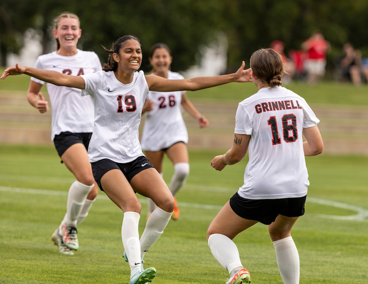 Grinnell College Women's soccer players celebrate a goal.