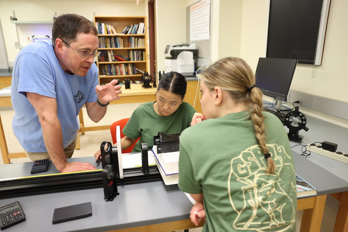 Two female GSP students collaborate with a faculty member