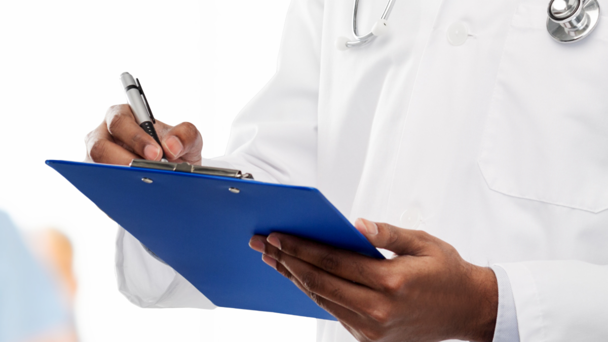 doctor writing on blue clipboard; close up of hands