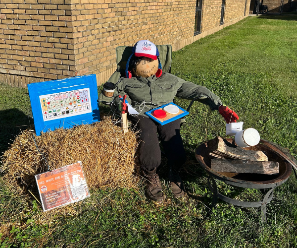 Photo of Fairfield DD's Scarecrow Techy Tim roasting marshmallows and using his AAC device.