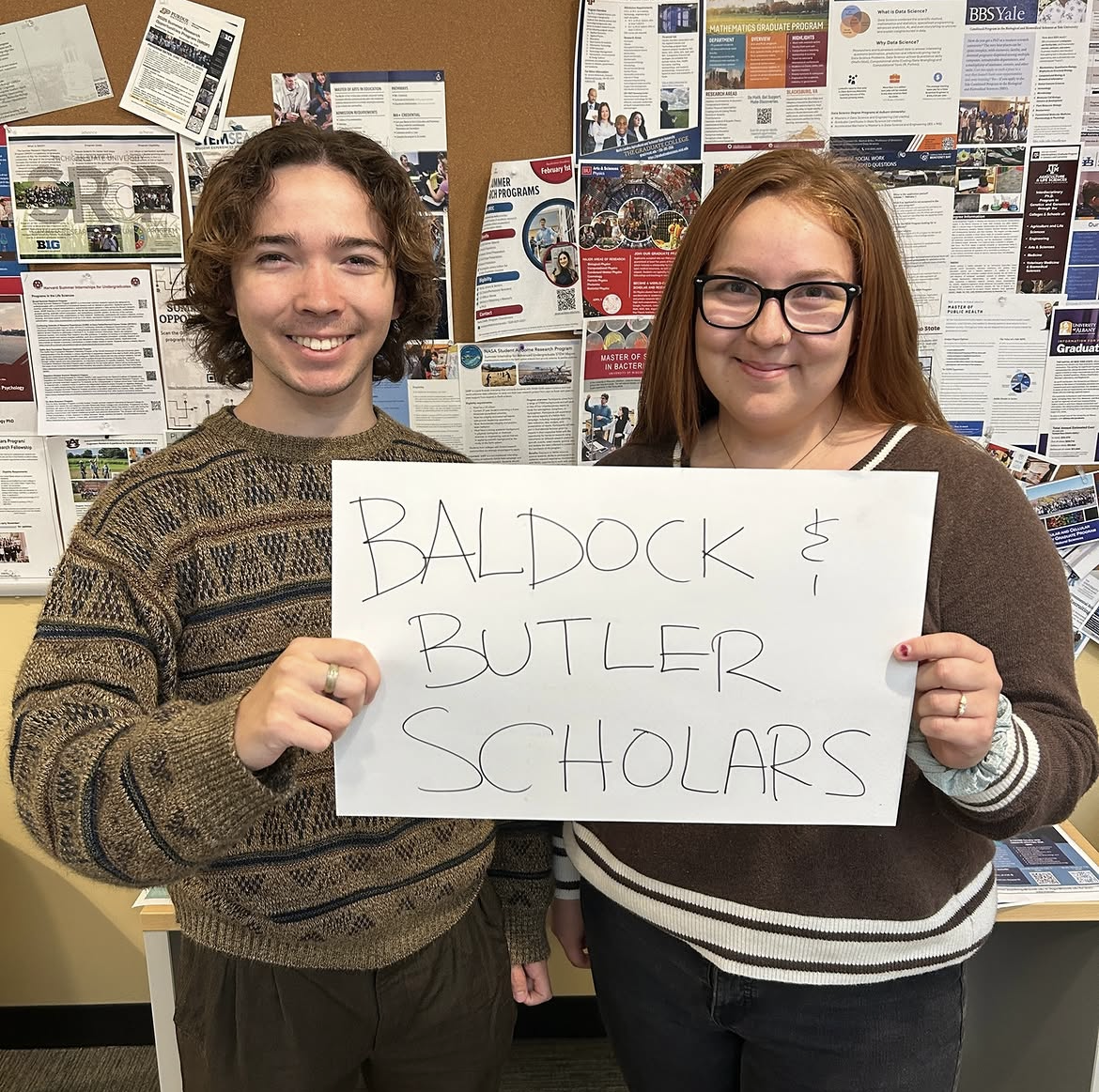 Soren Maxfield-Sawada and Lily Myers holding sign that reads "baldock and butler scholars"